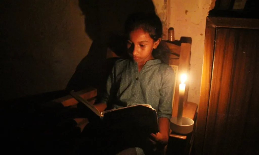 student studying by candlelight in Sri Lanka