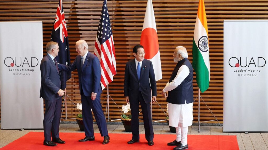 Quad members with national flags in the background