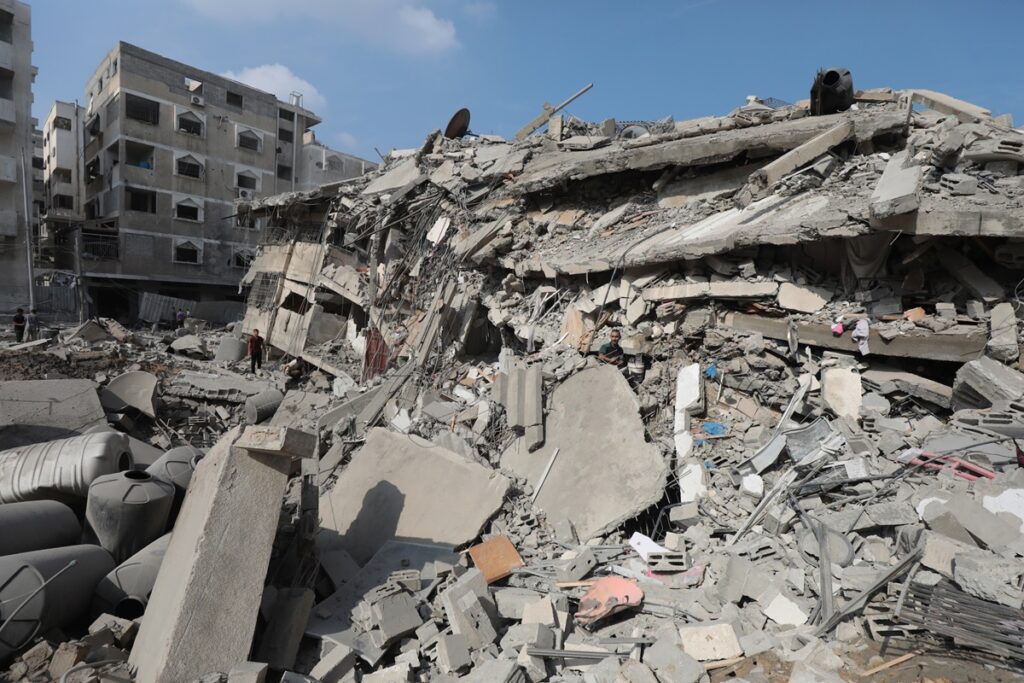 Palestinians inspect the ruins of Aklouk Tower destroyed in Israeli airstrikes in Gaza City